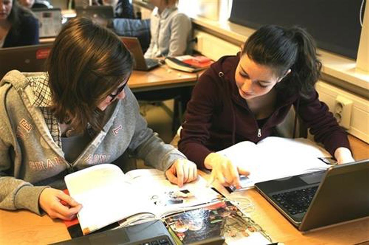 Elevar ved pultane i klasserommet.